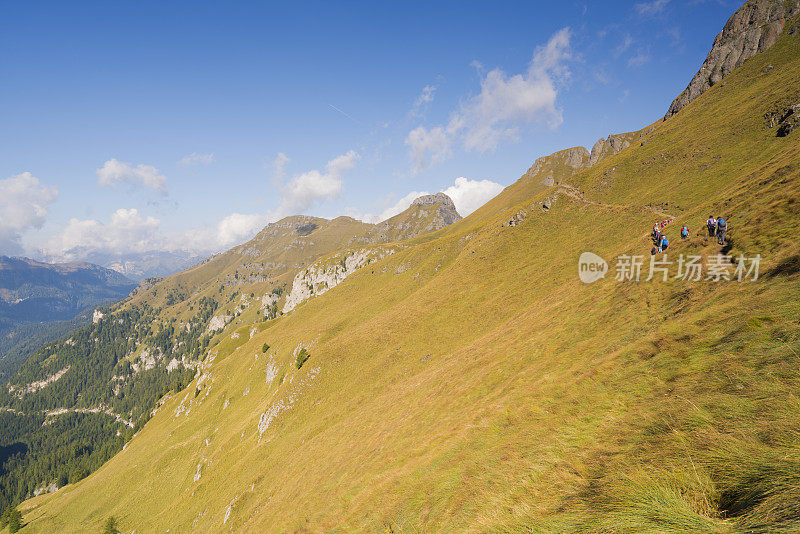 游客徒步在陡峭的斜坡上从Fedaia pass通过Pordoi在Dolomites，意大利北部Viel dei Pan路径。